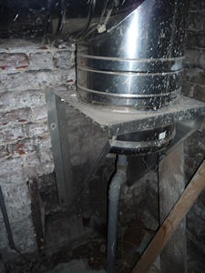 Photo partie inférieure du conduit de cheminée munie d'un conduit d'évacuation des condensats.